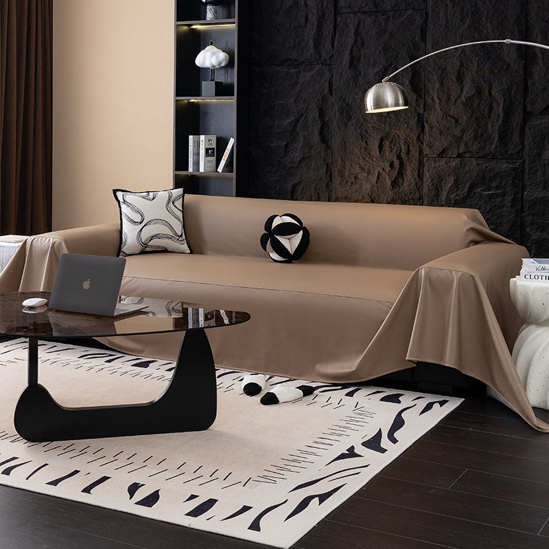 Sofaüberwurf aus Kunstleder Taupe, über ein Sofa gelegt
